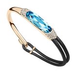 Luxe gouden fashion armband met blauwe edelsteen._