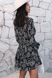 Zwarte korte jurk met witte bloemenprint._