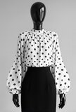 Elegante witte blouse met zwarte stippen en volumineuze mouwen_