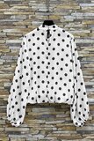 Elegante witte blouse met zwarte stippen en volumineuze mouwen_