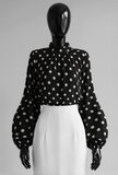 Elegante zwarte blouse met beige stippen en volumineuze mouwen_