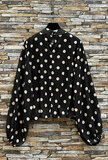 Elegante zwarte blouse met beige stippen en volumineuze mouwen_