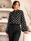 Elegante zwarte blouse met beige stippen en volumineuze mouwen_
