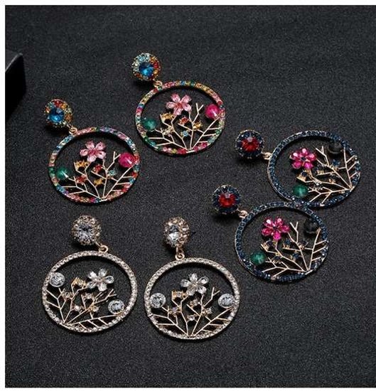 Blauwe trendy oorbellen met fuchsia bloem.