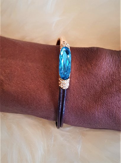 Luxe gouden fashion armband met blauwe edelsteen.