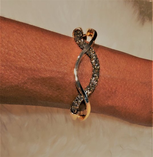 Gouden design armband met zwarte strass.