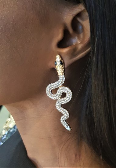 Gouden oorbellen in slangvorm met witte strass.