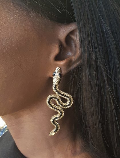 Gouden oorbellen in slangvorm met zwarte en witte strass.