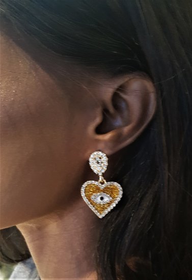 Gele oorbellen in hartvorm met oog en strass.