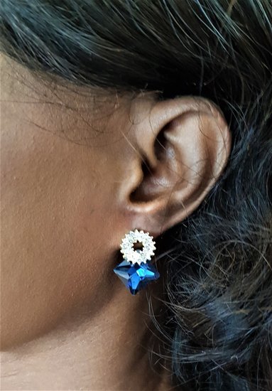 Blauwe vierkante oorbellen met bloemmotief.