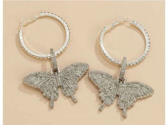 Grote zilveren oorbellen met vlindermotief.