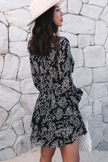 Zwarte korte jurk met witte bloemenprint.