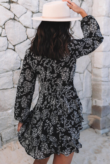 Zwarte korte jurk met witte bloemenprint.