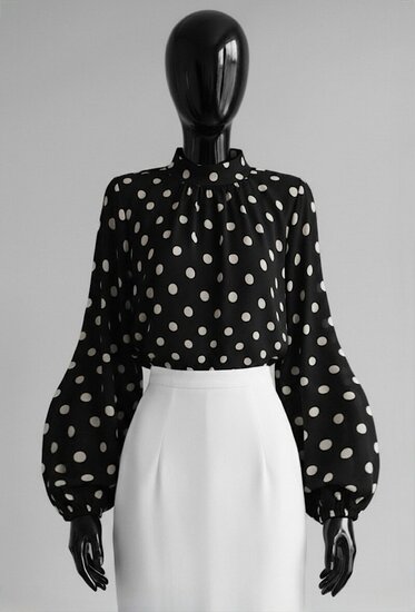 Elegante zwarte blouse met beige stippen en volumineuze mouwen